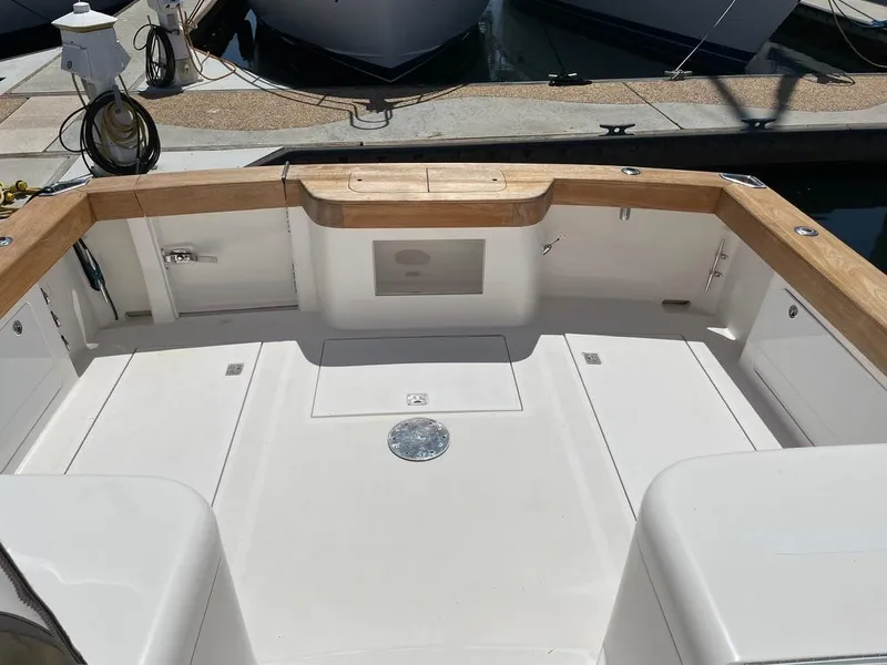 Slide: The Image of 2004 Cabo 35 Express boat deck with wooden trim, docked at marina. - 10