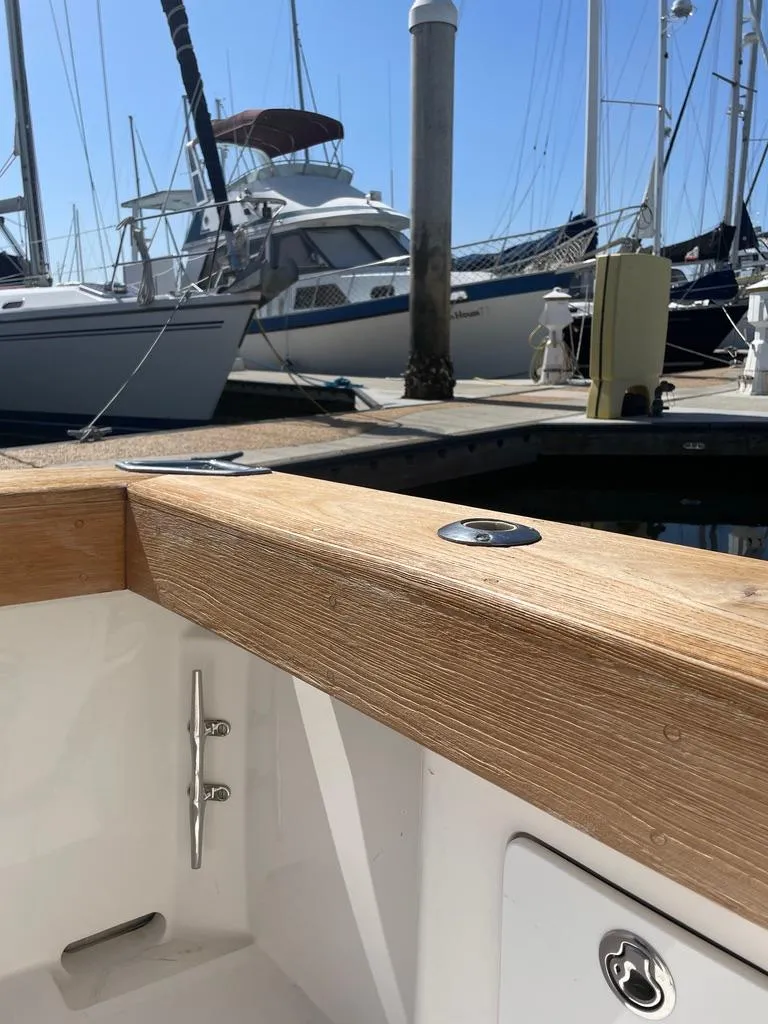 Slide: The Image of 2004 Cabo 35 Express boat docked at marina with wooden rail detail. - 12