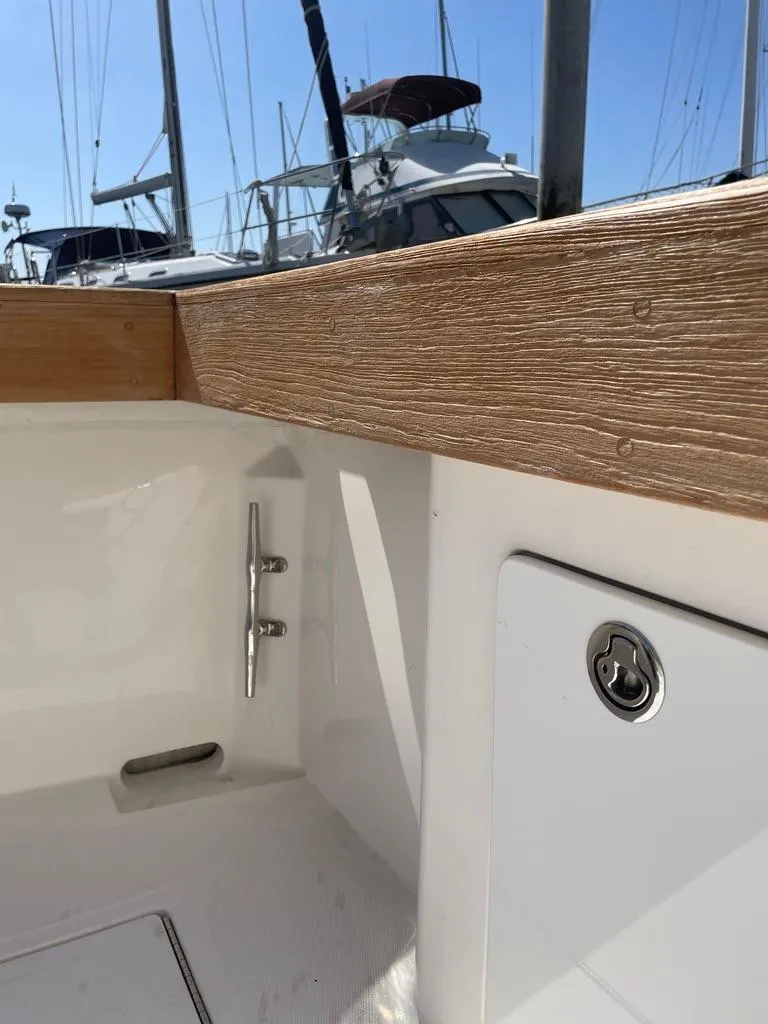 Slide: The Image of 2004 Cabo 35 Express boat interior with wood trim and docked yachts in background. - 13