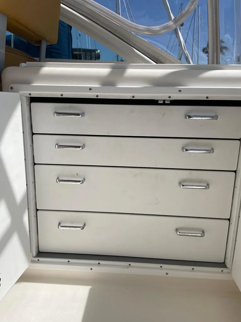 Slide: The Image of White storage drawers on a 2004 Cabo 35 Express boat, featuring sleek metal handles. - 16