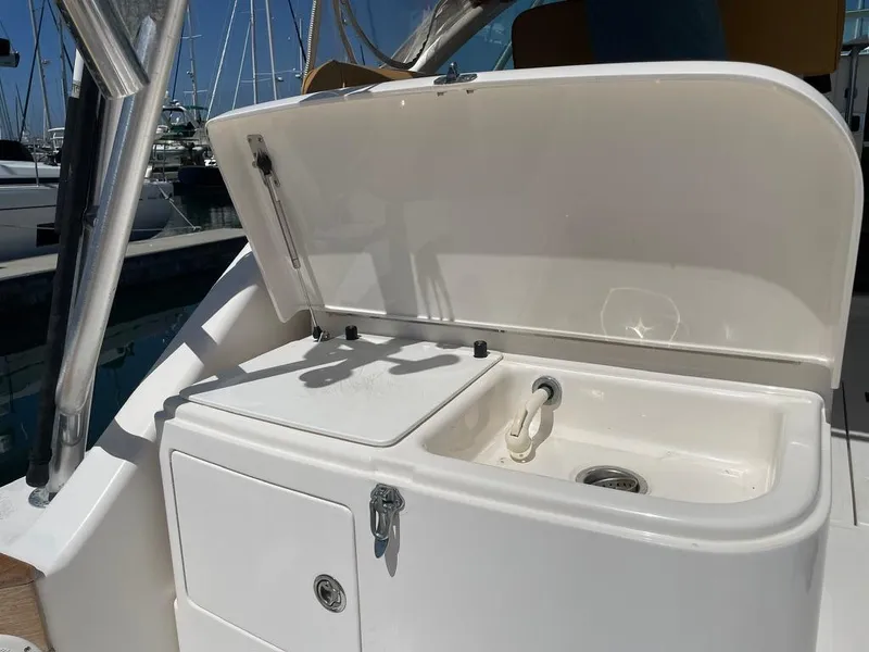 Slide: The Image of 2004 Cabo 35 Express boat sink and storage area with open lid. - 17