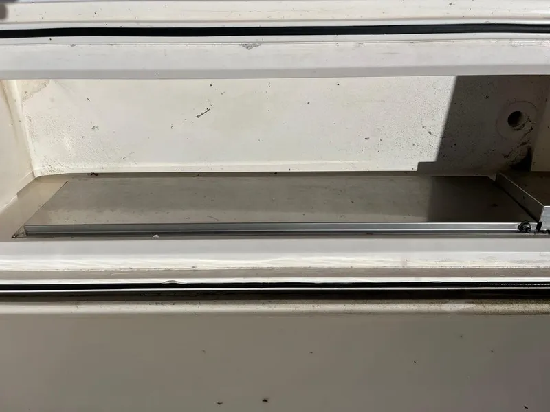 Slide: The Image of Storage compartment on a 2004 Cabo 35 Express boat, featuring a clean, white interior. - 18