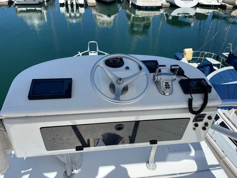 Slide: The Image of Helm of 2004 Cabo 35 Express boat with steering wheel and controls, docked in marina. - 20