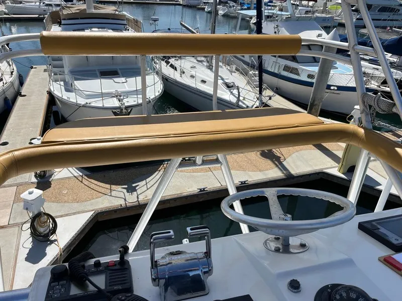 Slide: The Image of Helm of 2004 Cabo 35 Express yacht docked at marina, featuring steering wheel and controls. - 21