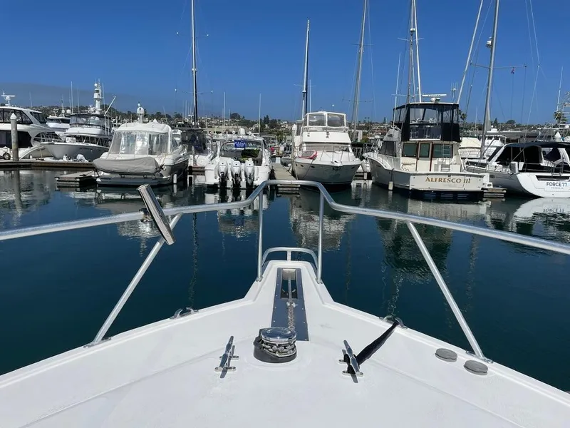 Slide: The Image of Bow view of 2004 Cabo 35 Express in a marina with multiple boats. - 23