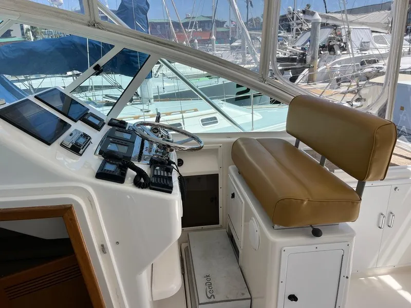 Slide: The Image of 2004 Cabo 35 Express helm with tan seating and navigation equipment. - 25