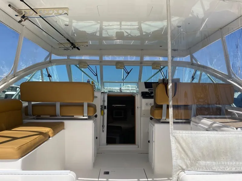 Slide: The Image of Interior of 2004 Cabo 35 Express boat with tan seating and clear windows. - 27