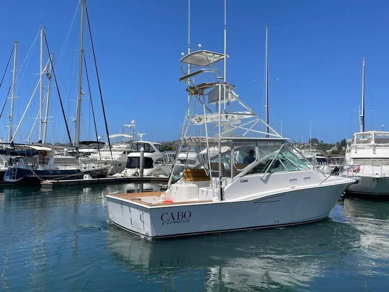 Slide: The Image of 2004 Cabo 35 Express boat docked in a marina, surrounded by other yachts. - 3