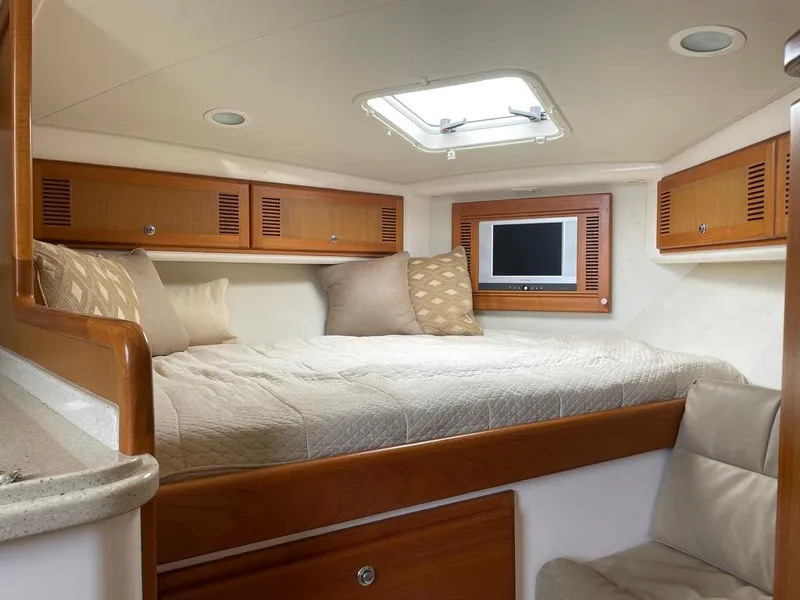 Slide: The Image of Luxurious cabin interior of 2004 Cabo 35 Express yacht with cozy bed and TV. - 30