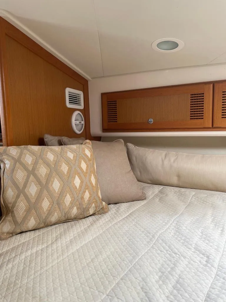 Slide: The Image of Cozy cabin interior of 2004 Cabo 35 Express with cushions and wood paneling. - 32