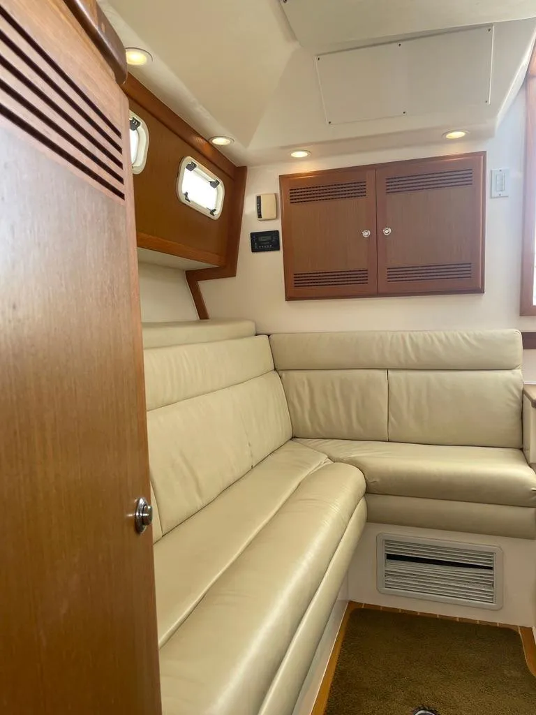 Slide: The Image of 2004 Cabo 35 Express interior with beige leather seating and wooden cabinets. - 34