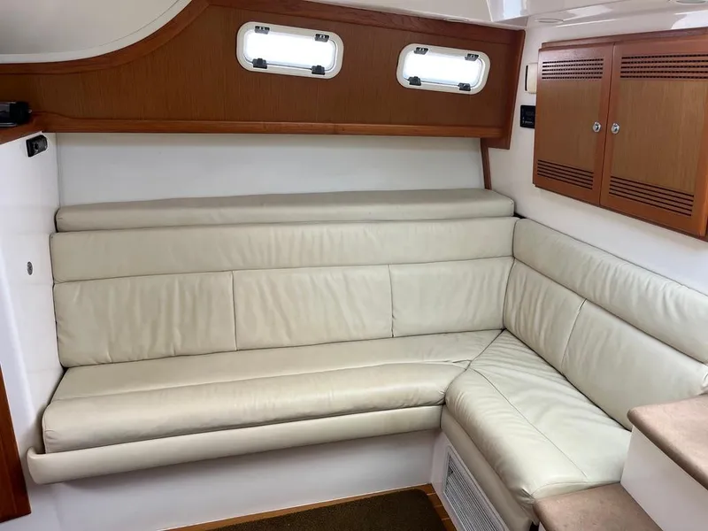 Slide: The Image of 2004 Cabo 35 Express interior with cream leather seating and wooden cabinets. - 35