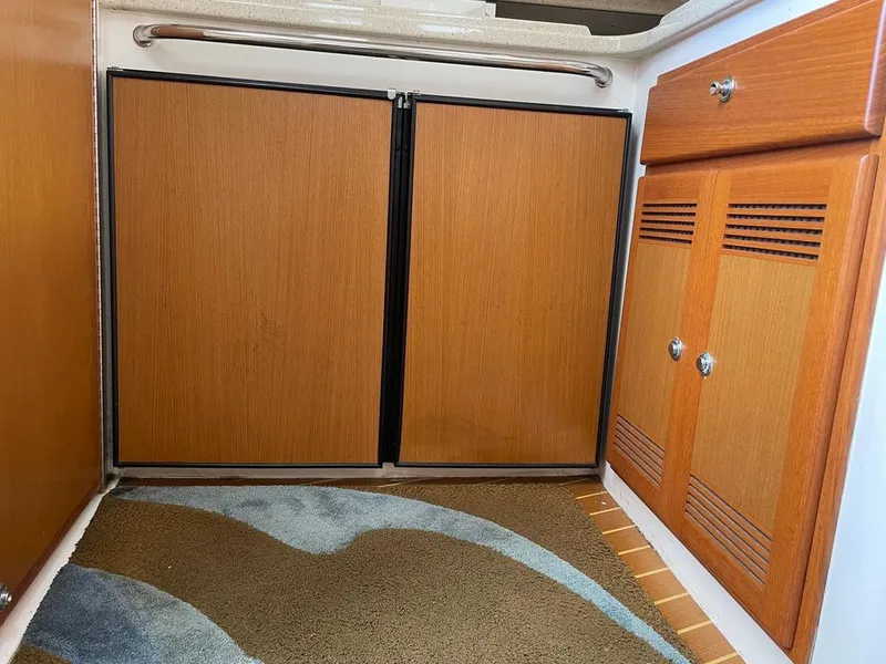 Slide: The Image of 2004 Cabo 35 Express interior with wooden cabinets and carpeted floor. - 37