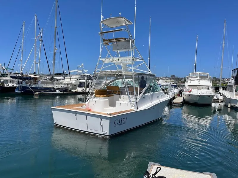 Slide: The Image of 2004 Cabo 35 Express boat docked in a marina under clear blue skies. - 4