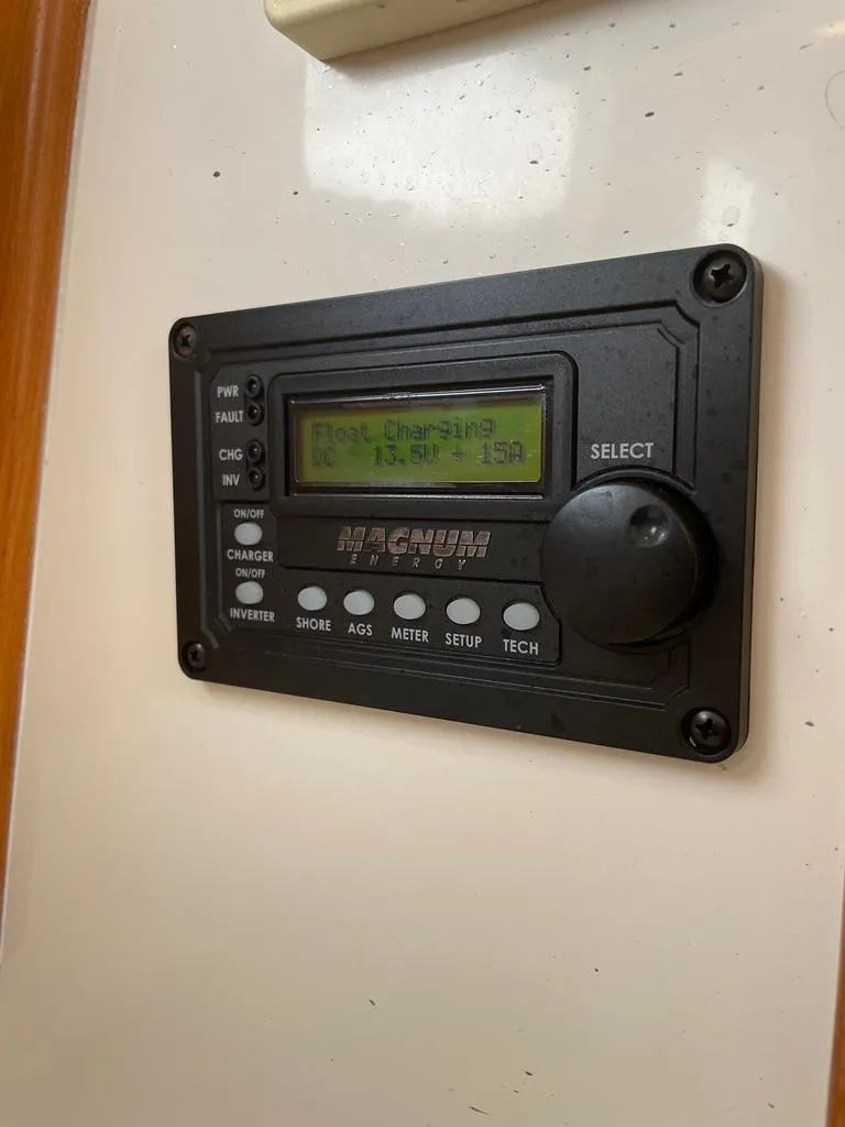 Slide: The Image of Magnum Energy control panel on 2004 Cabo 35 Express boat, displaying charging status. - 42