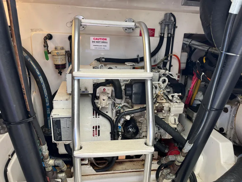 Slide: The Image of Engine compartment of a 2004 Cabo 35 Express boat with visible machinery and ladder. - 46