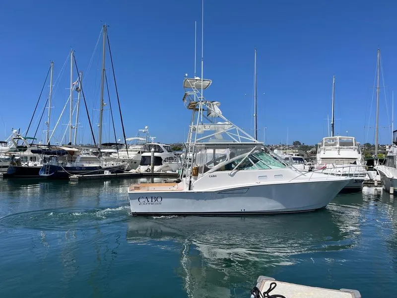 Slide: The Image of 2004 Cabo 35 Express boat docked in a marina with clear blue skies. - 5