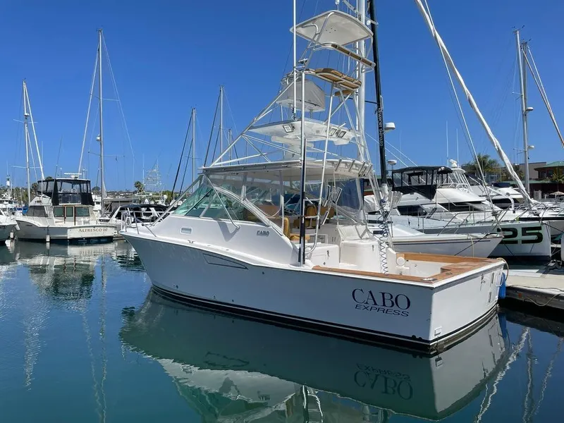 Slide: The Image of 2004 Cabo 35 Express boat docked in a marina under clear blue skies. - 6
