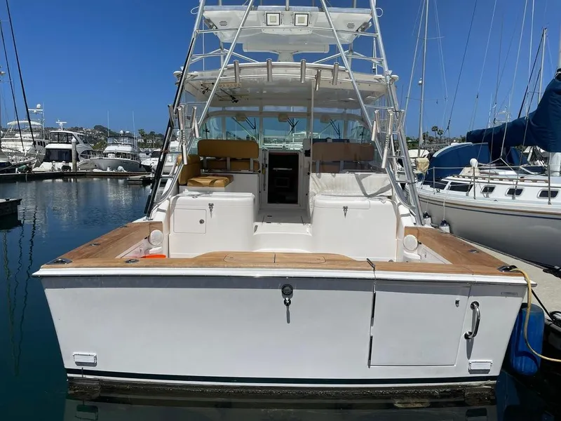 Slide: The Image of 2004 Cabo 35 Express boat docked in marina, rear view with clear sky. - 9