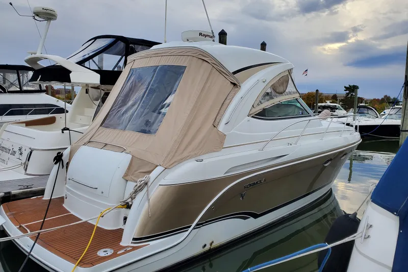 Slide: The Image of 2008 Formula 34 Performance Cruiser docked at marina, featuring sleek design and beige canopy. - 63