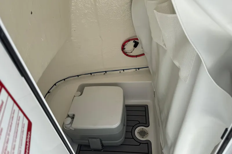 Slide: The Image of 2024 Tidewater 198 CC Adventure boat interior with compact marine toilet. - 17