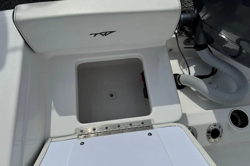 Slide: The Image of 2024 Tidewater 198 CC Adventure boat interior with storage compartment and hose connections. - 20