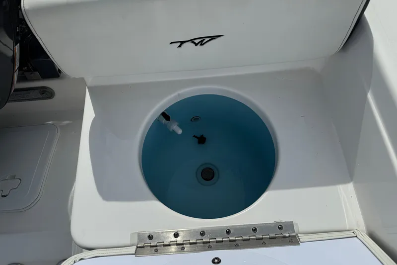 Slide: The Image of 2024 Tidewater 198 CC Adventure boat livewell with blue interior and TW logo. - 21