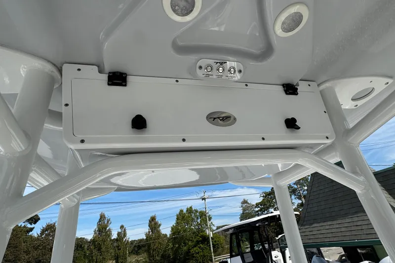Slide: The Image of 2024 Tidewater 198 CC Adventure boat console with storage and controls, under clear blue sky. - 7