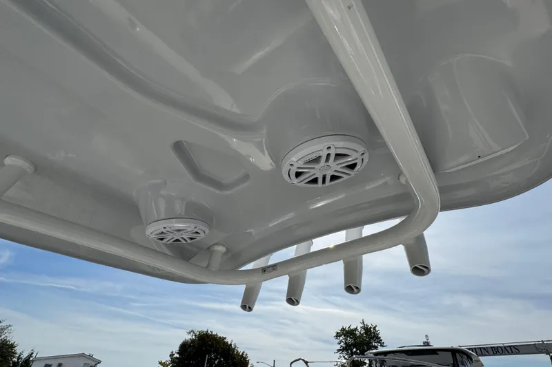 Slide: The Image of 2024 Tidewater 198 CC Adventure boat speakers and rod holders under T-top. - 8
