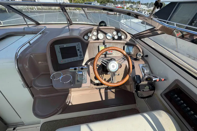 Slide: The Image of 2004 Regal Commodore 3560 boat helm with wooden steering wheel and navigation instruments. - 10