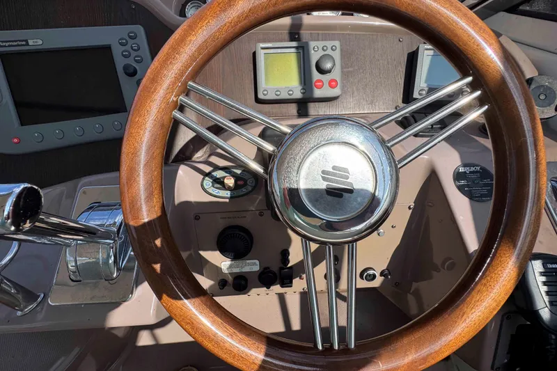 Slide: The Image of 2004 Regal Commodore 3560 helm with wooden steering wheel and navigation instruments. - 11