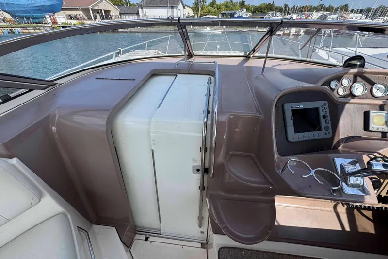 Slide: The Image of 2004 Regal Commodore 3560 helm with navigation controls and gauges, docked at marina. - 13