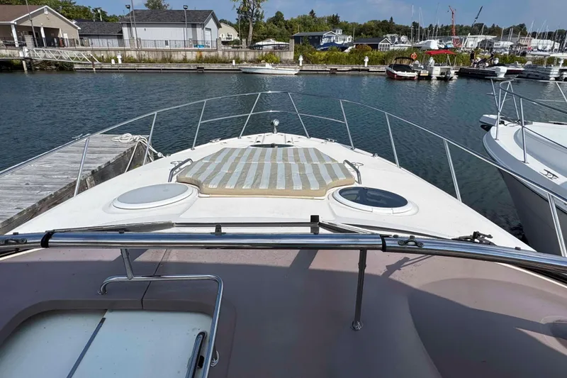 Slide: The Image of 2004 Regal Commodore 3560 yacht docked at marina, featuring spacious deck and scenic waterfront. - 15