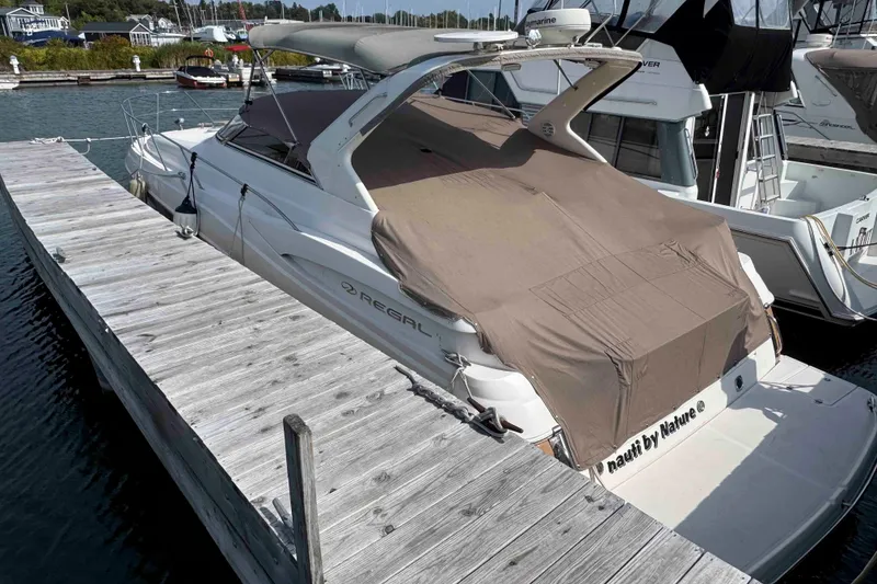 Slide: The Image of 2004 Regal Commodore 3560 yacht docked at marina with protective cover. - 18