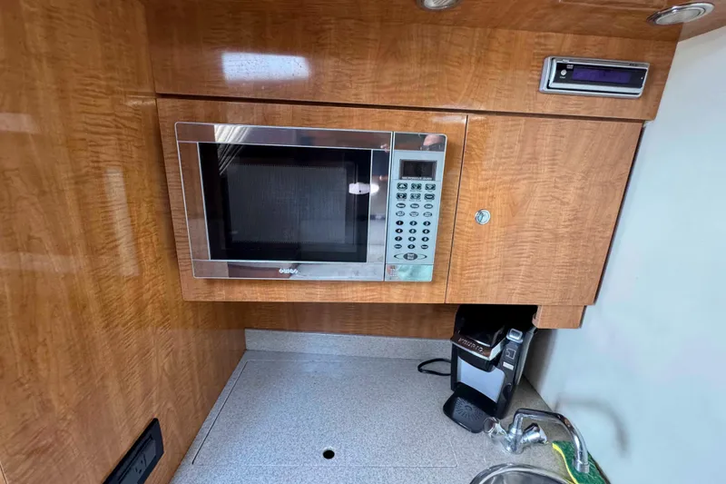 Slide: The Image of 2004 Regal Commodore 3560 yacht kitchen with microwave, coffee maker, and sink. - 24