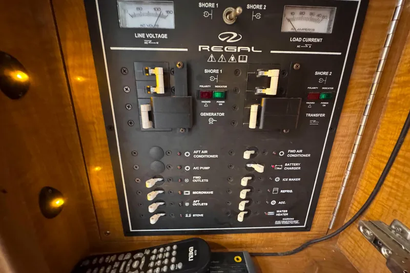 Slide: The Image of Electrical control panel of a 2004 Regal Commodore 3560 boat, featuring switches and meters. - 25