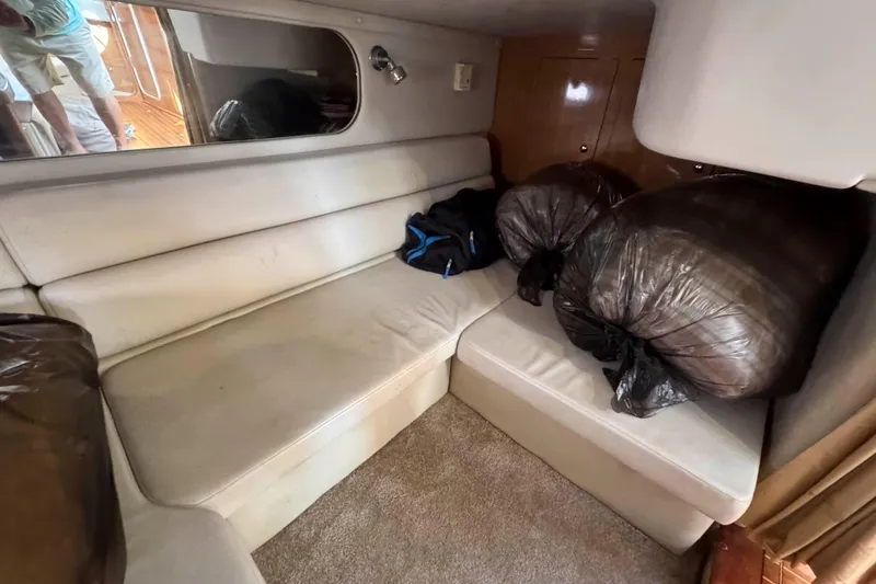 Slide: The Image of Interior of 2004 Regal Commodore 3560 yacht with beige seating and storage bags. - 28