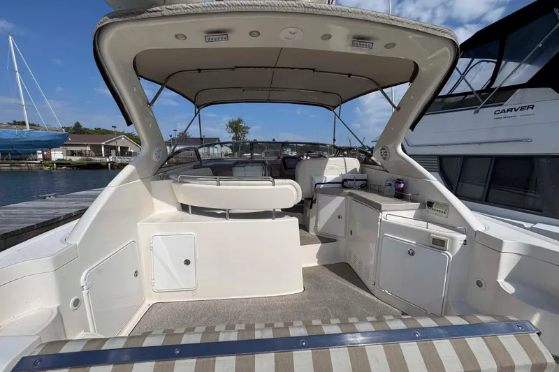 Slide: The Image of 2004 Regal Commodore 3560 yacht interior, featuring seating and cabinetry, docked at a marina. - 4