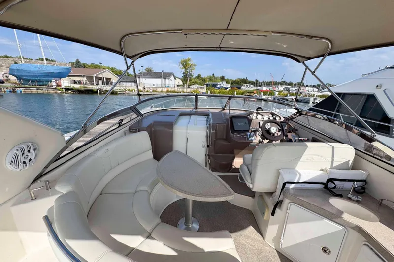 Slide: The Image of 2004 Regal Commodore 3560 yacht cockpit with seating, table, and helm, docked at marina. - 5