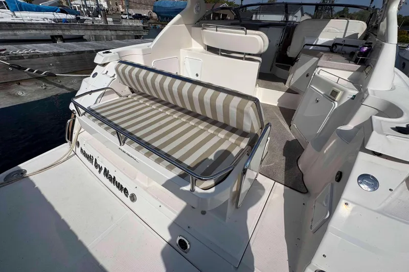 Slide: The Image of 2004 Regal Commodore 3560 yacht with striped seating, docked at a marina. - 7