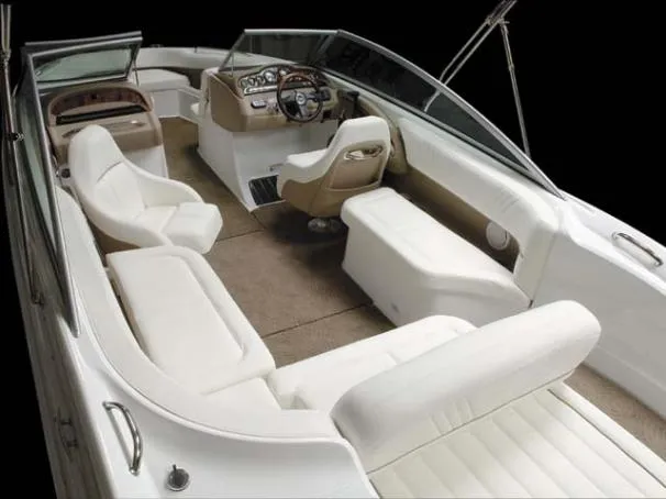 Slide: The Image of 2007 Cobalt 252 boat on trailer, parked outdoors, surrounded by trees and vehicles. - 1