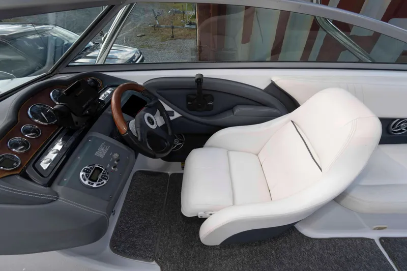 Slide: The Image of 2007 Cobalt 252 boat interior with white captain's chair and dashboard controls. - 7