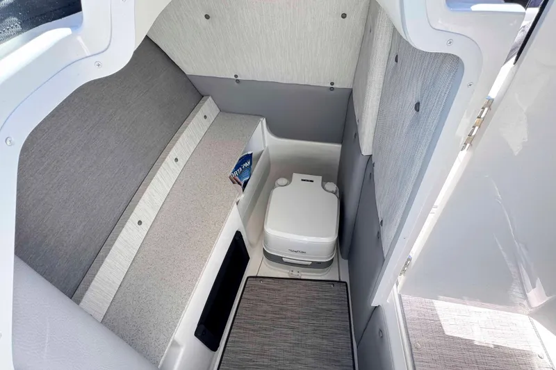 Slide: The Image of 2023 Cobalt R8 boat interior with compact toilet and seating area. - 23