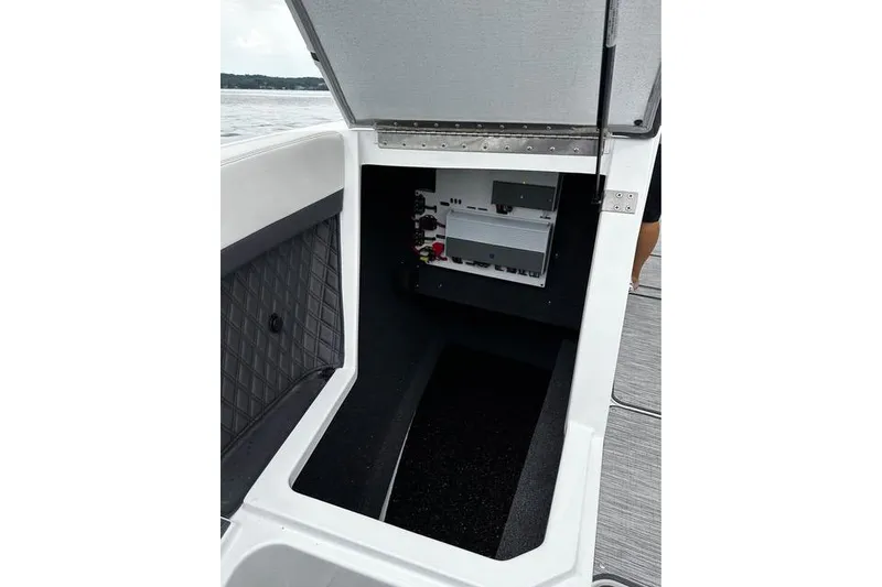 Slide: The Image of Open storage compartment in 2023 Cobalt R8 boat, showing interior electronics and wiring. - 29