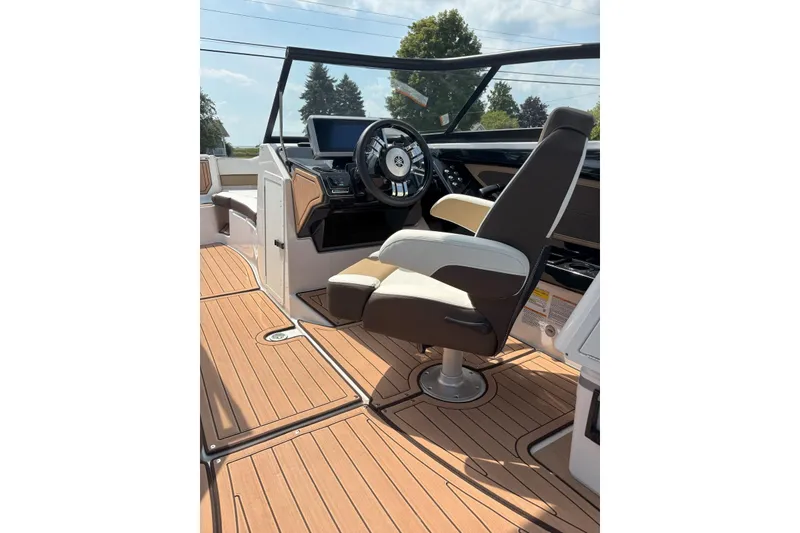 Slide: The Image of 2023 Yamaha Boats 252SD cockpit with modern steering and seating on teak flooring. - 6