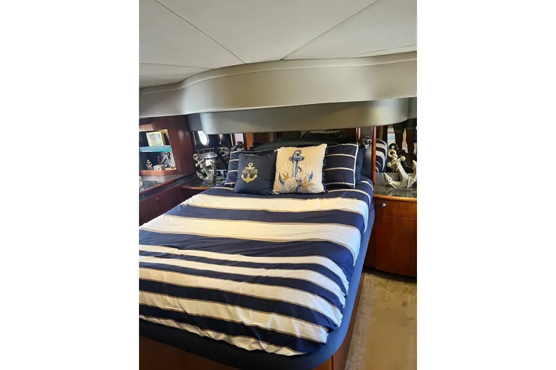 Slide: The Image of Luxurious bedroom in 2006 Cruisers Yachts 520 Express with nautical-themed decor. - 12