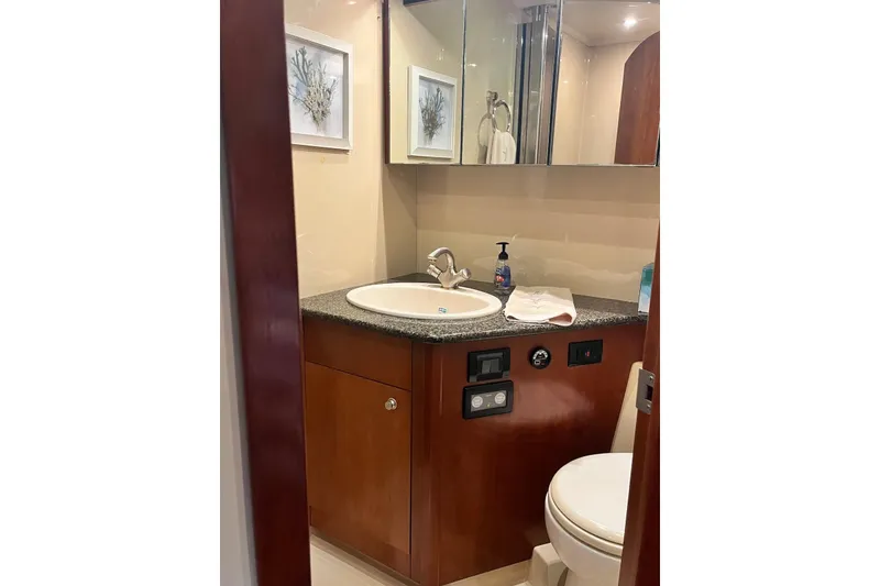 Slide: The Image of Luxurious bathroom in 2006 Cruisers Yachts 520 Express, featuring elegant wood cabinetry and modern fixtures. - 13