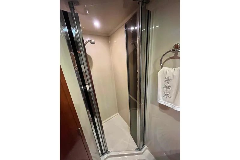 Slide: The Image of Shower area in 2006 Cruisers Yachts 520 Express, featuring glass doors and starfish towel. - 14