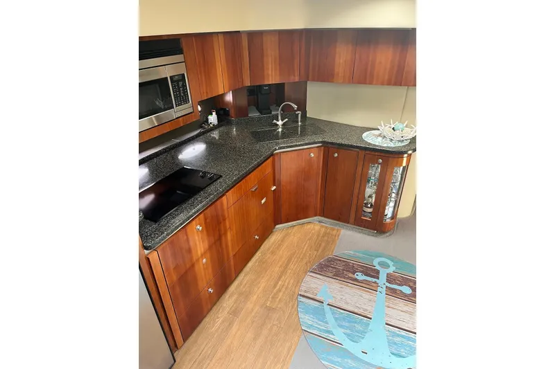 Slide: The Image of Luxurious 2006 Cruisers Yachts 520 Express kitchen with wood cabinetry and modern appliances. - 8