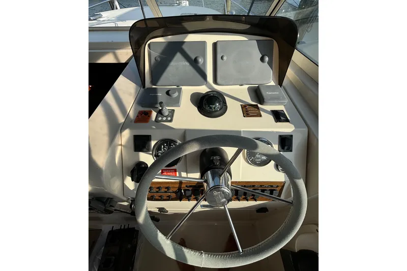 Slide: The Image of 2005 Mainship Pilot 34 helm with blue-striped seating and navigation controls. - 12